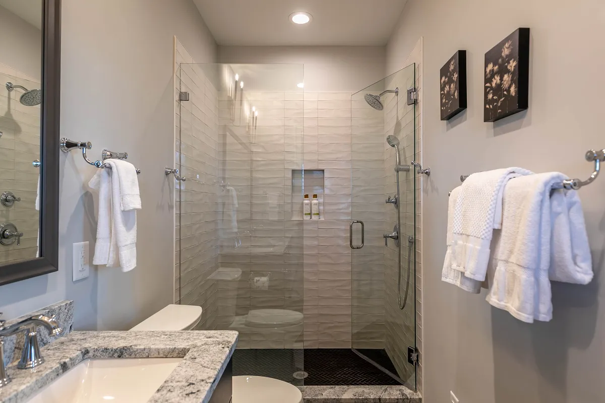 An inviting interior view of the spa and wellness area, featuring a modern glass shower enclosure, granite countertop, and tranquil décor. The scene exudes a sense of relaxation and self-care, perfect for a rejuvenating spa experience on-site.
