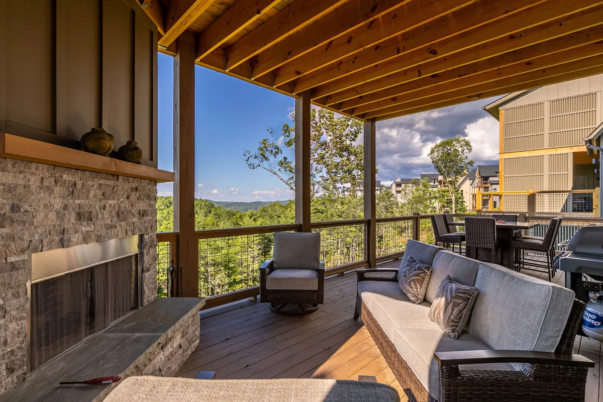 A welcoming outdoor stone fireplace with comfortable seating arranged to foster conversation and relaxation, set against a serene landscape. The space is ideal for winding down in the evening or sharing stories by the fire.